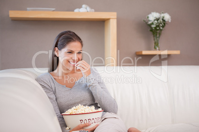 Woman having a bowl of popcorn while watching a movie