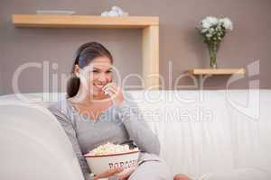 Woman having a bowl of popcorn while watching a movie