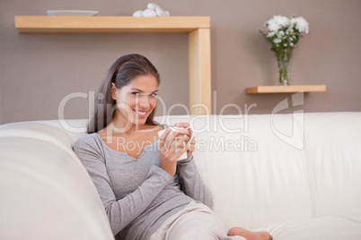 Woman with a cup of coffee on the sofa