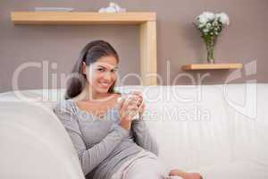 Woman with a cup of coffee on the sofa