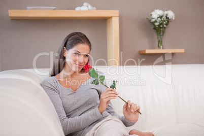Woman with a red rose sitting on the couch