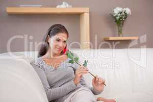 Woman with a red rose sitting on the couch