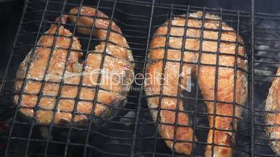 Barbecue grill with grilled salmon fish steaks panning