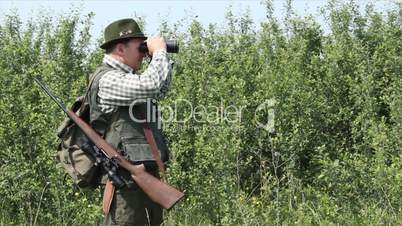 hunter with binoculars and rifle