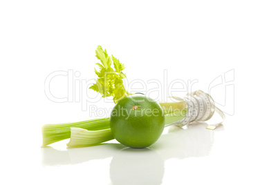 celery in a tall glass, green grapefruit and measure tape isolat