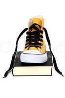 Yellow sneaker on black book