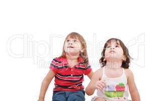 Two little girl looking up, two and four years old, isolated on
