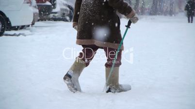 Elderly man walks at winter street