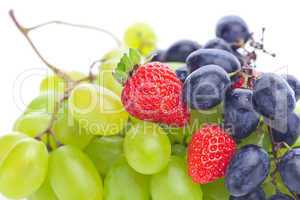 bunch of white and black grapes and strawberries isolated on whi