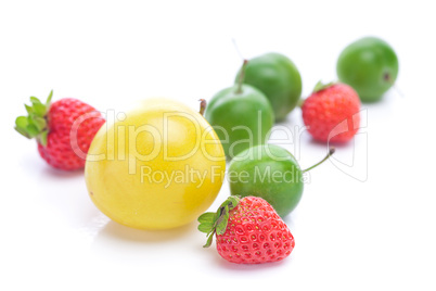 green and yellow plums and strawberries isolated on white