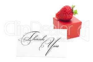 red gift box, thank you card and strawberries isolated on white