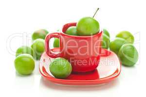 green plum  in the red cup isolated on white