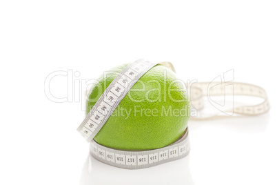 green grapefruit and measure tape isolated on white