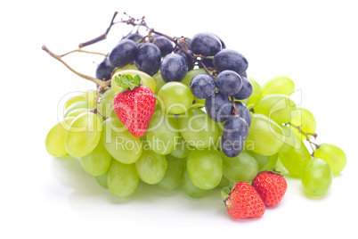 bunch of white and black grapes and strawberries isolated on whi