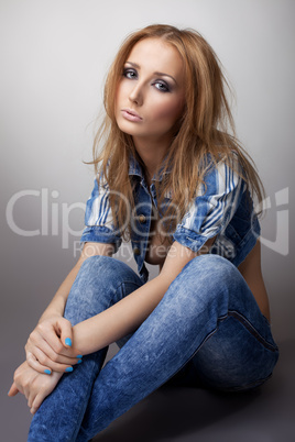 Beautiful girl sit in jeans and jacket