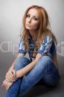 Beautiful girl sit in jeans and jacket
