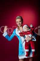 Beauty christmas girl play with baby santa claus