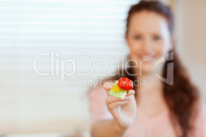 Mouthful of salad being offered by girl