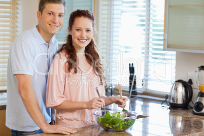 Couple with salad in the kitchen
