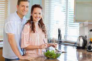 Couple with salad in the kitchen