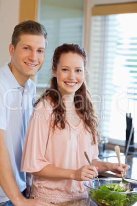 Couple with green salad in the kitchen