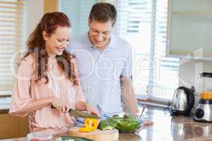 Man watching his girlfriend preparing a salad