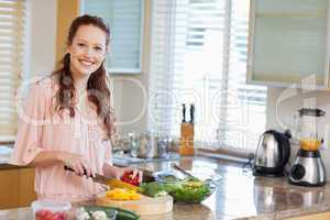 Smiling woman preparing salad