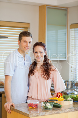 Young couple standing behind kitchen counter