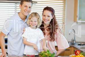 Smiling family preparing salad together