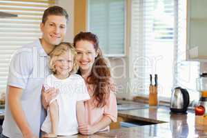 Smiling family standing behind the kitchen counter
