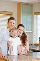 Cheerful family standing behind the kitchen counter