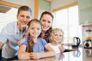 Family standing together behind the kitchen counter