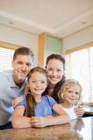 Happy family standing behind the kitchen counter