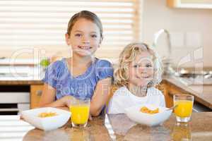 Siblings with breakfast behind the kitchen counter