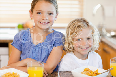 Brother and sister with breakfast in the kitchen