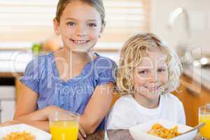 Brother and sister with breakfast in the kitchen