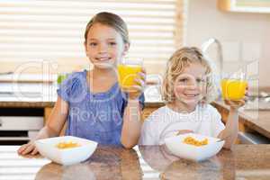 Siblings in the kitchen rising their glasses