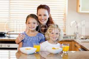 Mother with children and breakfast in the kitchen