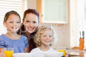 Smiling mother with her children in the kitchen