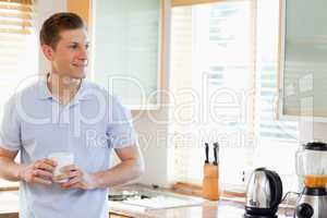 Man holding cup in the kitchen