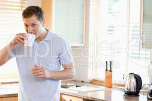 Man having a sip of coffee in the kitchen