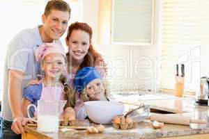 Family with baking ingredients behind the kitchen counter