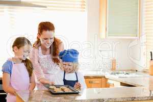 Mother presenting finished cookies to her children