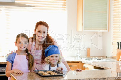 Mother with children and cookies in the kitchen