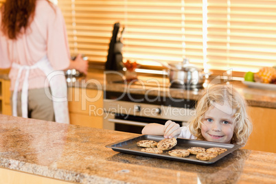 Boy stealing a cookie while his mother is not watching