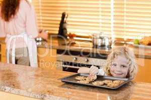 Boy stealing a cookie while his mother is not watching