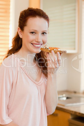 Smiling woman holding slice of bread