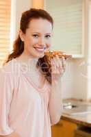 Smiling woman holding slice of bread