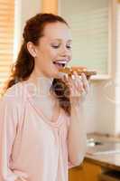 Woman biting into slice of bread