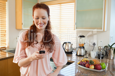 Woman in the kitchen writing text message